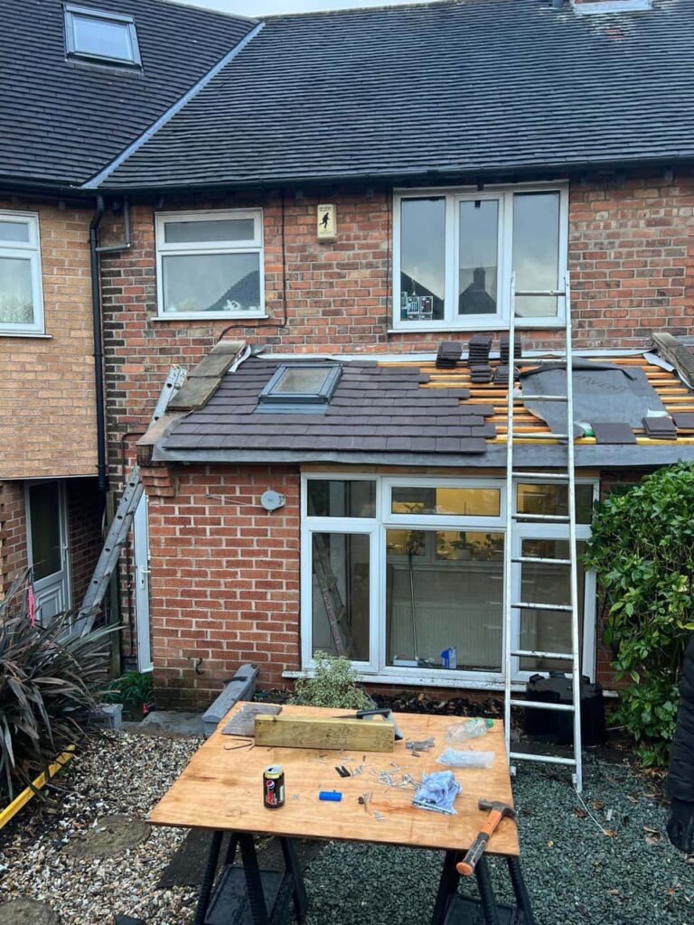 This is a photo of a roof extension that is having new roof tiles installed. This is a photo taken from the roof ridge looking down a tiled pitched roof on to a flat roof. Works carried out by TRP Roofing Willerby